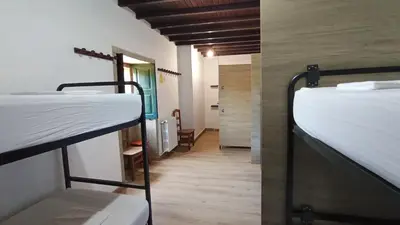 a room with three bunk beds in it at La Calabaza del Peregrino in O Faramello
