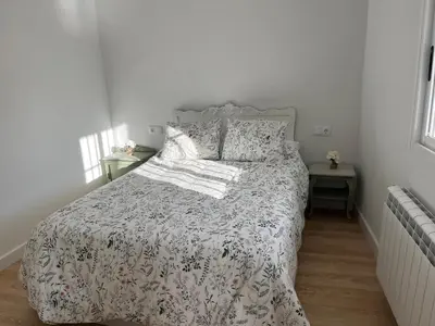 a bedroom with a bed with a floral bedspread at Casa Catalina - Ribeira Sacra in Abeleda
