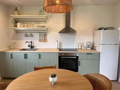 a kitchen with a table and a white refrigerator at Casa Catalina - Ribeira Sacra in Abeleda