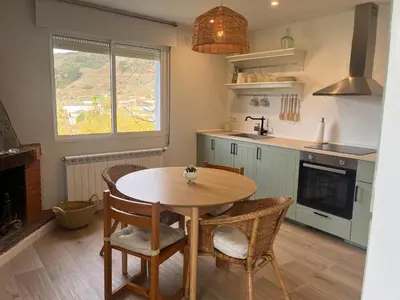 a kitchen with a table and chairs in a kitchen at Casa Catalina - Ribeira Sacra in Abeleda