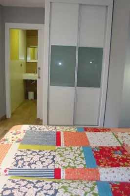 a bedroom with a bed with a quilt on it at Hostal El Recanto in Vega de Valcarce