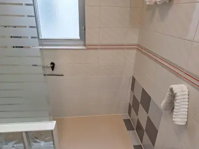 a bathroom with a shower with a glass door at Piso Premium en Casco Histórico Vistas a la Ría Parking in Viveiro