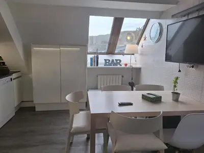 a kitchen and dining room with a table and chairs at Piso Premium en Casco Histórico Vistas a la Ría Parking in Viveiro