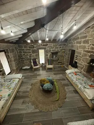 a large room with two beds and a table at Aturuxo, Casa dos Mestres in Trasmiras