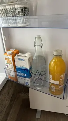 a refrigerator with a bottle of milk and a jug of orange juice at Aturuxo, Casa dos Mestres in Trasmiras