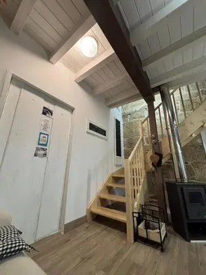 a living room with a staircase and a television at Aturuxo, Casa dos Mestres in Trasmiras