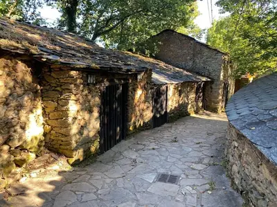 an old stone building with a gate and a stone walkway at Casa Vilachá - Ribeira Sacra in Puebla del Brollón