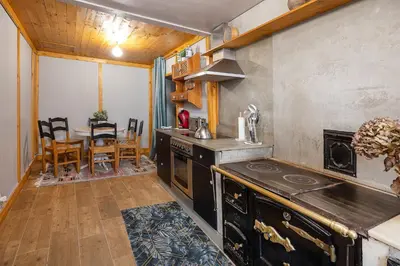 a kitchen with a stove and a dining table at YourHouse A Casa Dos Cregos in Fonteita