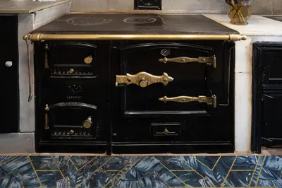 an old black stove with two doors in a room at YourHouse A Casa Dos Cregos in Fonteita
