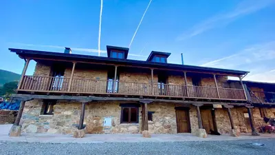 a large stone building with a balcony on it at la solana del abuelo Andrés in La Chana