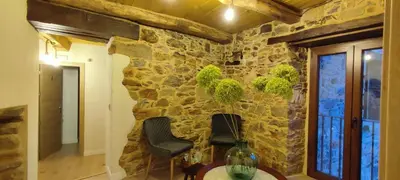 a room with two chairs and a stone wall at la solana del abuelo Andrés in La Chana