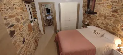 a bedroom with a bed and a stone wall at la solana del abuelo Andrés in La Chana