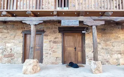 a building with two wooden doors and a balcony at la solana del abuelo Andrés in La Chana