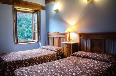 a bedroom with two beds and a window at Casas Rurales Taramundi Verde in Taramundi