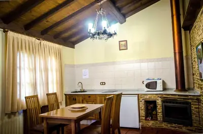 a kitchen with a table and a dining room at Casas Rurales Taramundi Verde in Taramundi