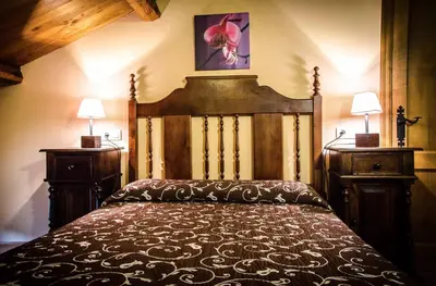 a bedroom with a large bed with a wooden headboard at Casas Rurales Taramundi Verde in Taramundi