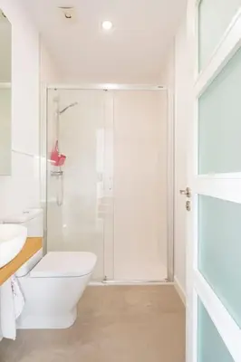 a white bathroom with a shower and a toilet at Casa Taboada in San Román