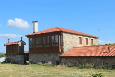 a house with a red roof on a field at Casa Taboada in San Román