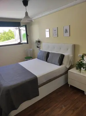 a bedroom with a large white bed and a window at Val de Lemos in Monforte de Lemos