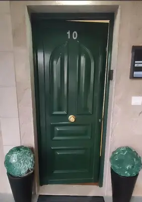 a green door in a building with two trash cans at Val de Lemos in Monforte de Lemos