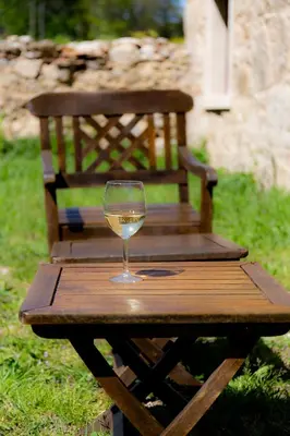 a glass of wine sitting on a wooden picnic table at O Rincón de Esther in Vedra