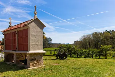 a small church sitting in a field with a grass field at O Rincón de Esther in Vedra
