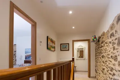 a staircase in a house with a stone wall at O Rincón de Esther in Vedra
