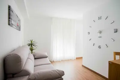 a living room with a couch and a clock on the wall at Hotel Gastronómico Gandainas in Riós