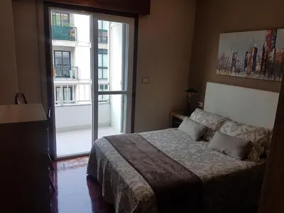 a bedroom with a bed and a large window at El Descanso de Ana in Ourense