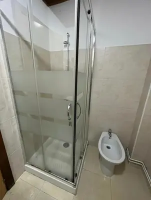 a bathroom with a shower and a toilet at Pension Matias Rooms in Sarria