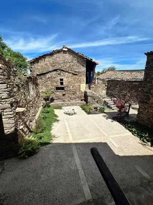 a stone building with a parking lot in front of it at Casa Dona Ildara in Doade