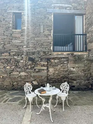 two chairs and a table with a tea set on a patio at Casa Dona Ildara in Doade