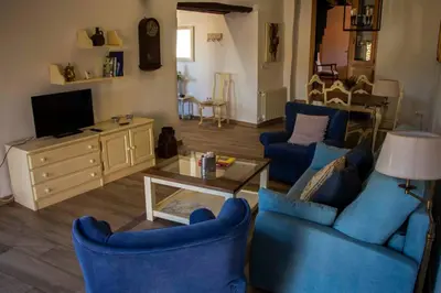 a living room with blue chairs and a coffee table at Casa Dona Ildara in Doade