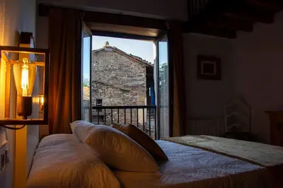 a bedroom with a bed and a large window at Casa Dona Ildara in Doade