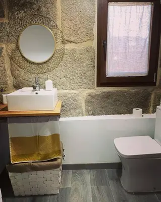 a bathroom with a sink and a toilet and a mirror at Casa Vilar (Taboadela-Ourense) in Taboadela