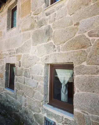 a window of a stone building with a tie in it at Casa Vilar (Taboadela-Ourense) in Taboadela