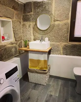 a bathroom with a sink and a washing machine at Casa Vilar (Taboadela-Ourense) in Taboadela
