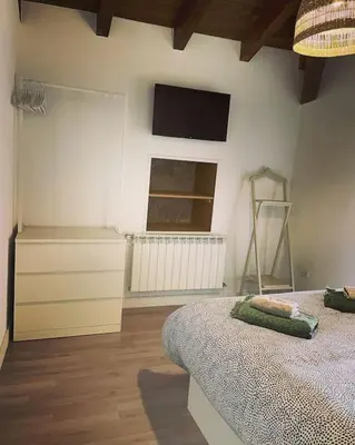 a bedroom with a bed and a tv on the wall at Casa Vilar (Taboadela-Ourense) in Taboadela