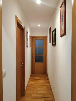 a hallway with a wooden door and pictures on the walls at ALE HOSPEDAJE GALICIA in Temple