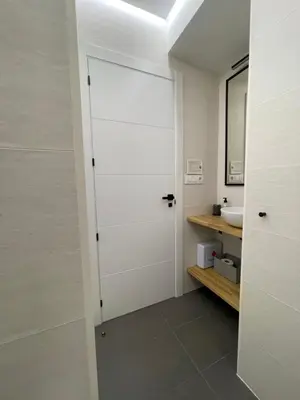a bathroom with a white door and a sink at C&G Ático Céntrico con Terraza in Ourense