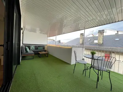 a room with a table and chairs on a balcony at C&G Ático Céntrico con Terraza in Ourense