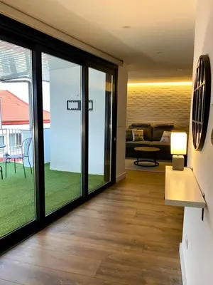 a living room with sliding glass doors and a couch at C&G Ático Céntrico con Terraza in Ourense