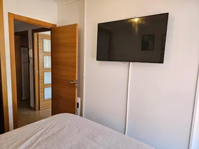 a bedroom with a flat screen tv on a wall at Los Castelos by Urraca Suites Viveiro in Viveiro