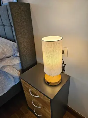 a lamp on a night stand next to a bed at Los Castelos by Urraca Suites Viveiro in Viveiro