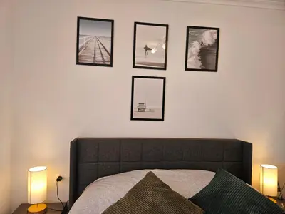 a bedroom with a bed with four pictures on the wall at Los Castelos by Urraca Suites Viveiro in Viveiro