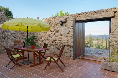 a table and chairs with an umbrella on a patio at Casa Del Ingles - Luxury Private Villa & Pool in Rural Valley in Pontevedra
