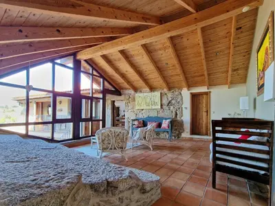a room with a bed and a table and some windows at Casa Del Ingles - Luxury Private Villa & Pool in Rural Valley in Pontevedra