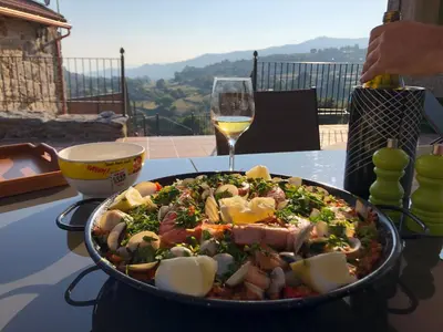 a plate of food on a table with a glass of wine at Casa Del Ingles - Luxury Private Villa & Pool in Rural Valley in Pontevedra