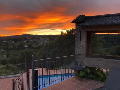 a sunset view of a pool from a house at Casa Del Ingles - Luxury Private Villa & Pool in Rural Valley in Pontevedra
