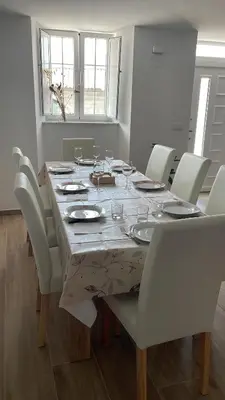 a dining room table with white chairs and a table cloth at A casa de Lago in Lago